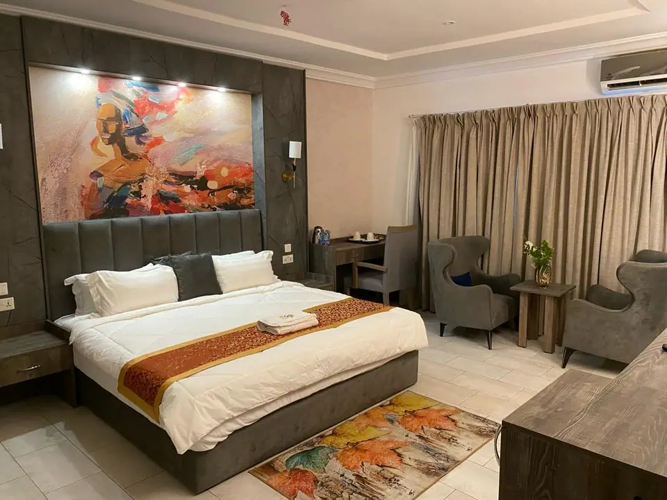 Spacious guest room with king bed, abstract art and seating area