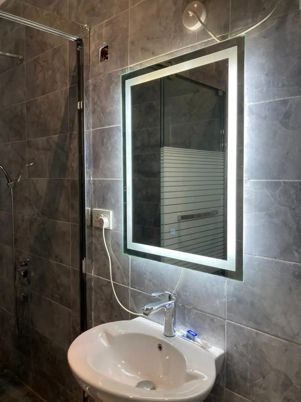 Basin and illuminated mirror in a Superior Room bathroom